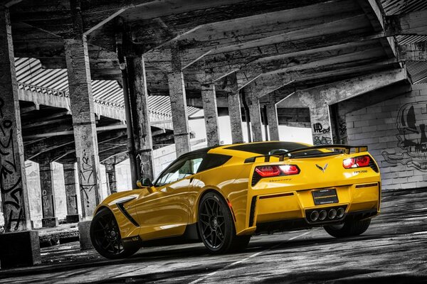 A yellow Chevrolet stands on a black and white background