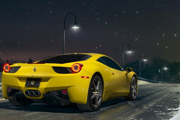 A chic yellow Ferrari on the background of a snowy night sky