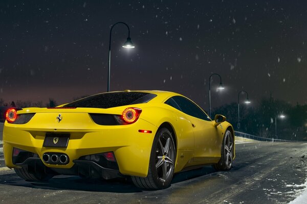 Elegante Ferrari gialla sullo sfondo del cielo notturno innevato