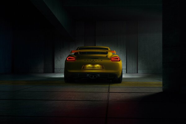 Giallo Porsche gt4 in camera buia vista posteriore