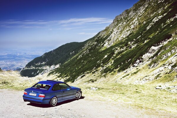 Auto di colore blu sullo sfondo delle montagne