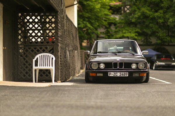 Black BMW e28 car on a green background