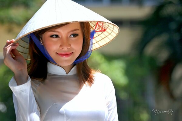 Sorridente bella ragazza asiatica in un cappello Vietnamita