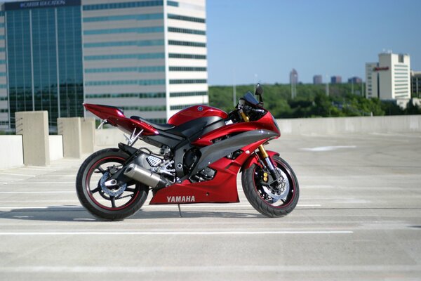 A red motorcycle on a spanking outside the building