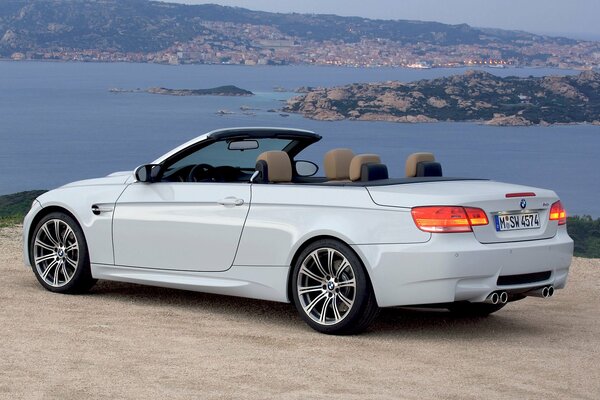 White convertible BMW m3. beautiful view of the evening city and the sea