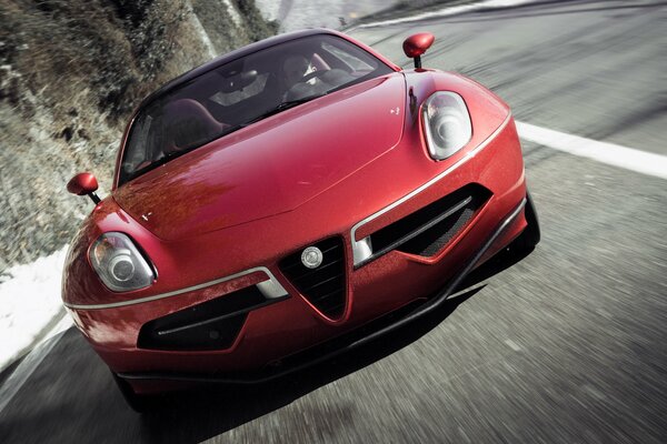 Red alfa romeo volante in the mountains front view