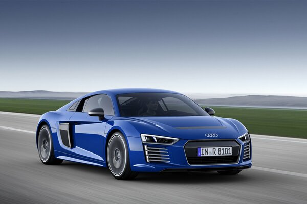 A blue Audi is driving on the road