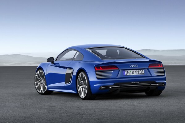 A blue Audi is driving along the road