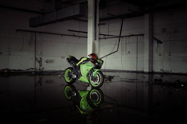 Green Yamaha motorcycle in an abandoned building