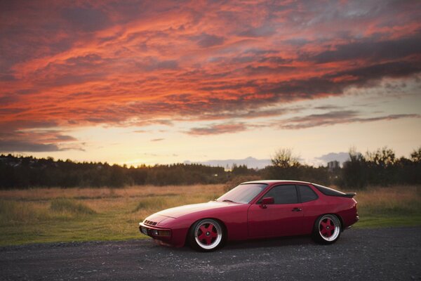 Porsche rouge sur fond de coucher de soleil rouge