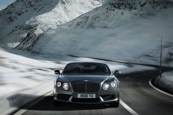 Bentley continental V8 plateado en la carretera de invierno