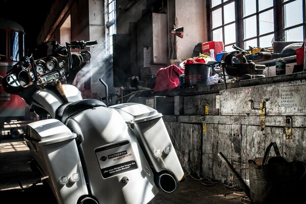 A disassembled motorcycle in an old garage