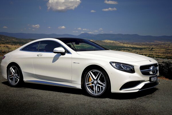 White Mercedes Amg with a beautiful landscape