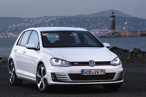 Volkswagen golf de color blanco en el fondo de la ciudad