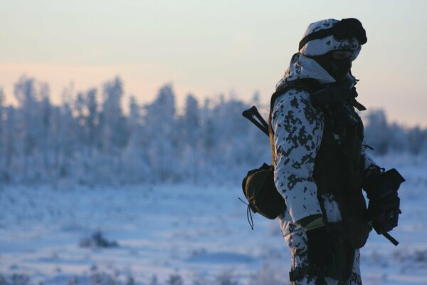 Soldado en el campo de invierno con armas