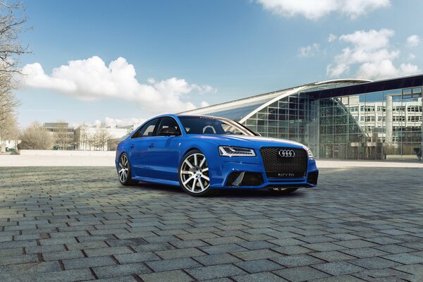 Blue Audi with white wheels in the city