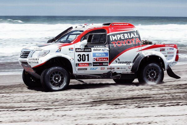 Un SUV Toyota en course sur la plage de la mer