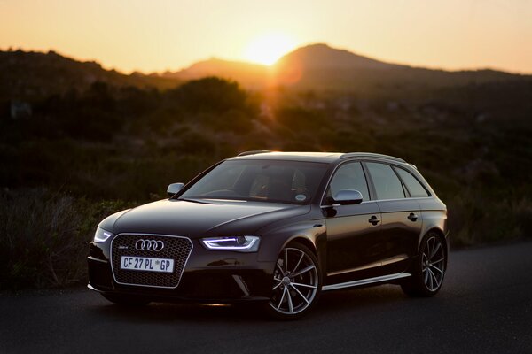 Schwarzer Audi rs4 auf Sonnenuntergang Hintergrund