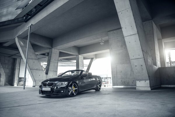 Black bmw e93 convertible on a gray building background