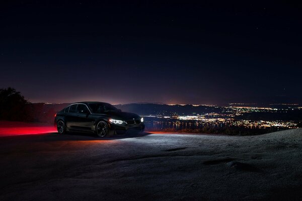 Un automóvil con luces de neón se encuentra en una colina desierta a Última hora de la noche