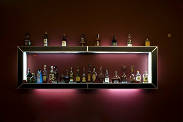 Bar with bottles of alcohol on a dark background with backlight