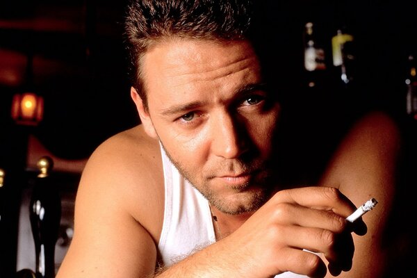 Russell Crowe in a T-shirt sat down for a smoke