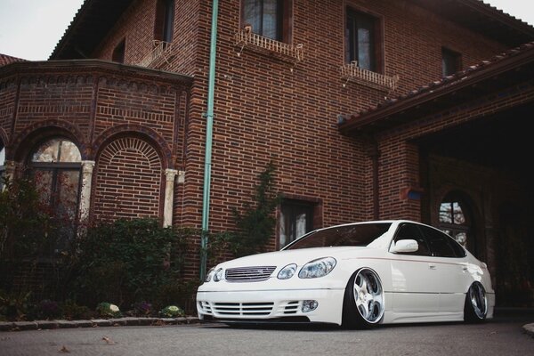 White car on the background of a brick house