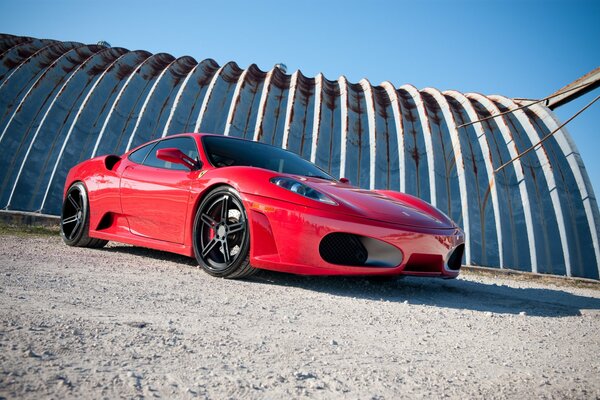 Red Ferrari car on the background of a white canopy