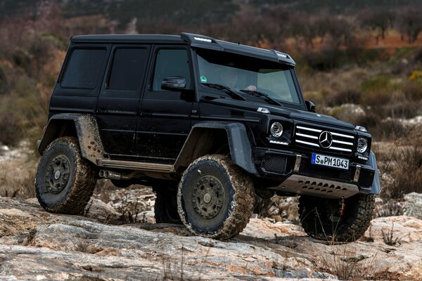 Schwarzer Allradantrieb Mercedes benz G-Klasse auf Steinen