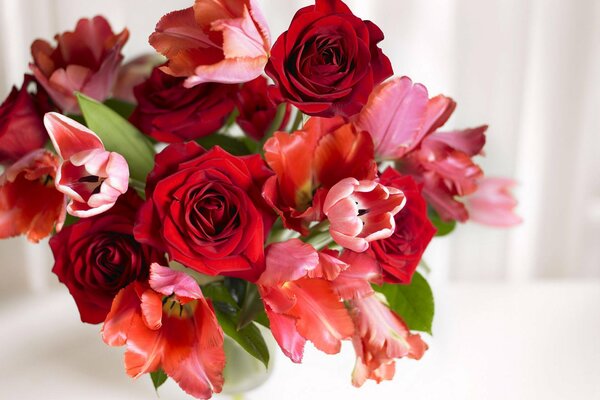 Fragante ramo de rosas y tulipanes en un jarrón
