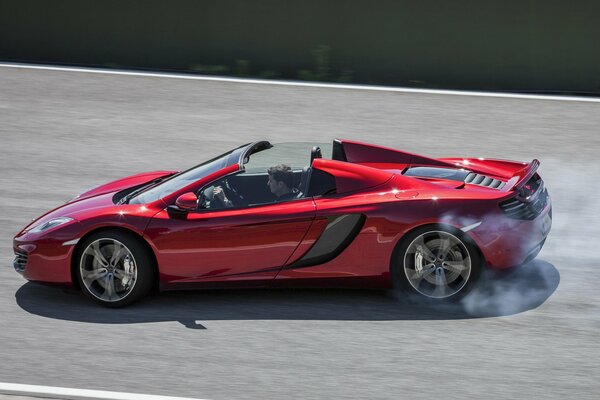 Ein leuchtend rotes Spider McLaren Cabrio mit hoher Geschwindigkeit