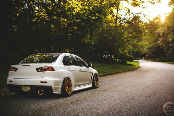 Mitsubishi white car on the background of nature and the road