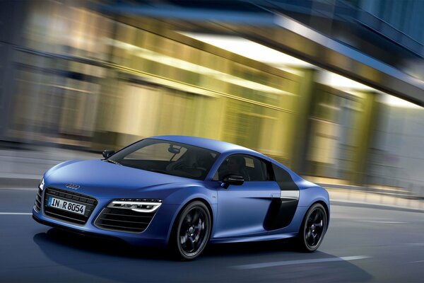 Blue audi car on the background of the city in motion