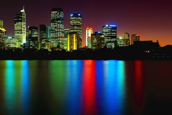 Reflejos de colores de las luces de la ciudad en el agua