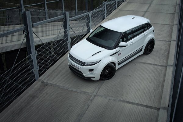 There is a beautiful, white car on the bridge