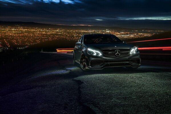 Mercedes noire sur fond de ville de nuit