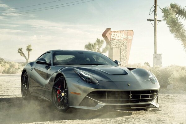 Black ferrari f12 car in the dust from the road