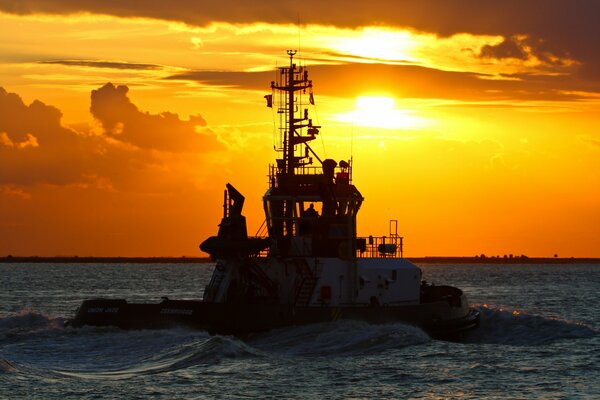 Navire sur fond de magnifique coucher de soleil sur la mer