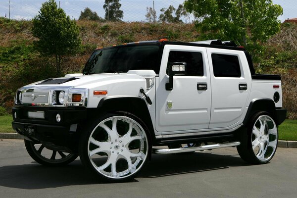 Белый тюнингованный внедорожник HUMMER ASANTI H2 на фоне обвала