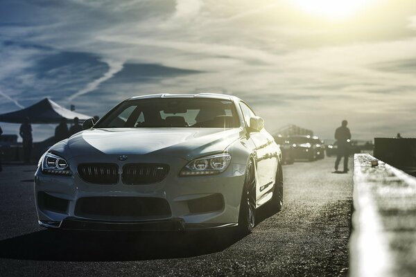 Bild eines BMW-Autos auf einem Hintergrund von Wolken und einem Mann