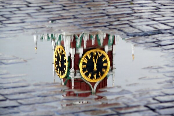 Reflection of the Kremlin chimes in a puddle