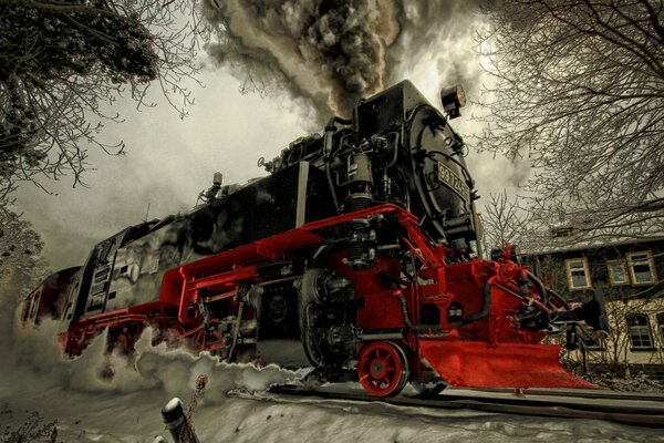 Una locomotora de vapor pintada cabalga sobre rieles cubiertos de nieve