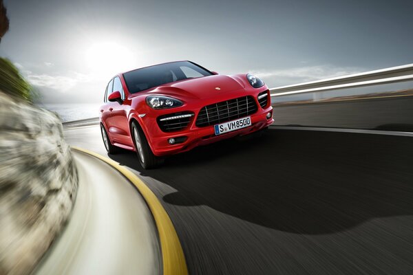 Coche Porsche rojo en el fondo de la carretera