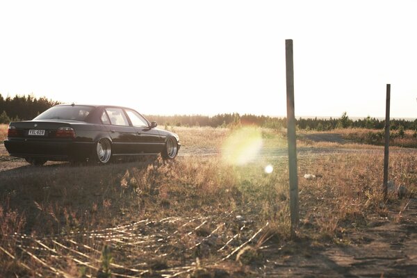 A car on a slippery road against the background of trees and meadows