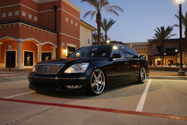 Voiture noire de marque lexus sur le fond de la ville du soir