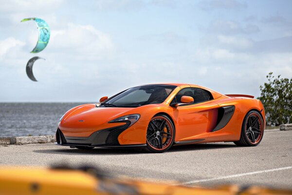 Supercar arancione McLaren sulla costa