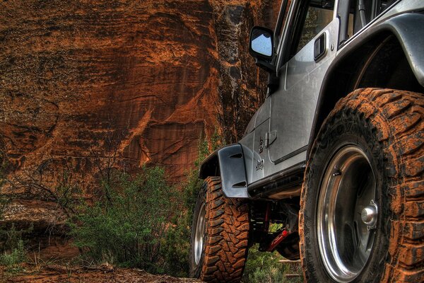Black jeep at the mountains and rocks in the sand