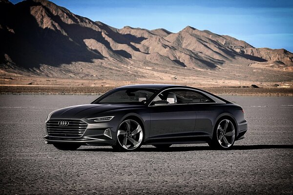 A chic black Audi car on the background of mountains