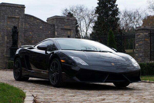 Lambirghini noir sur fond de mur de pierre