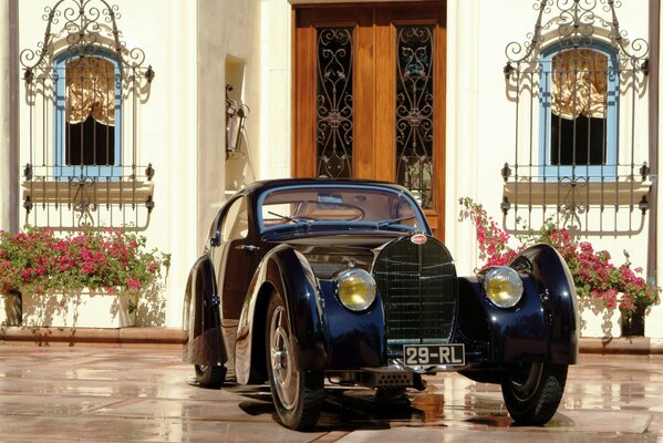 Classic Bugatti car 1931 on the background of a luxurious mansion